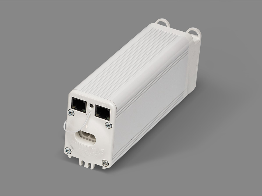 Białe, prostokątne urządzenie z dwoma portami i otworem na szarym tle.